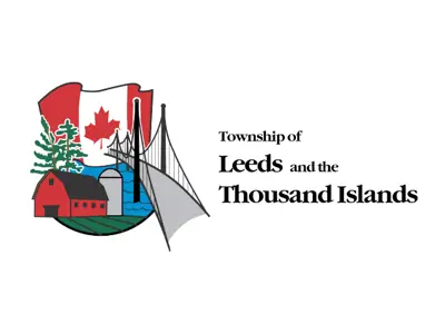 Township logo consisting of a Canadian flag, red barn, silo, bridge and body of water with the text, Township of Leeds and the Thousand Islands